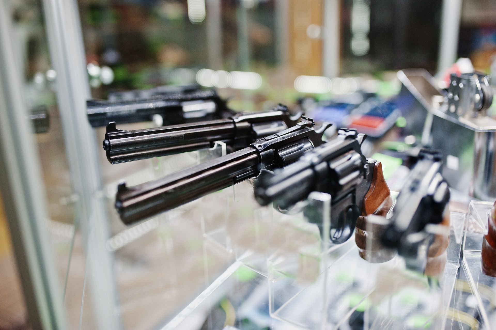 Guns on display inside a glass case at a shop.